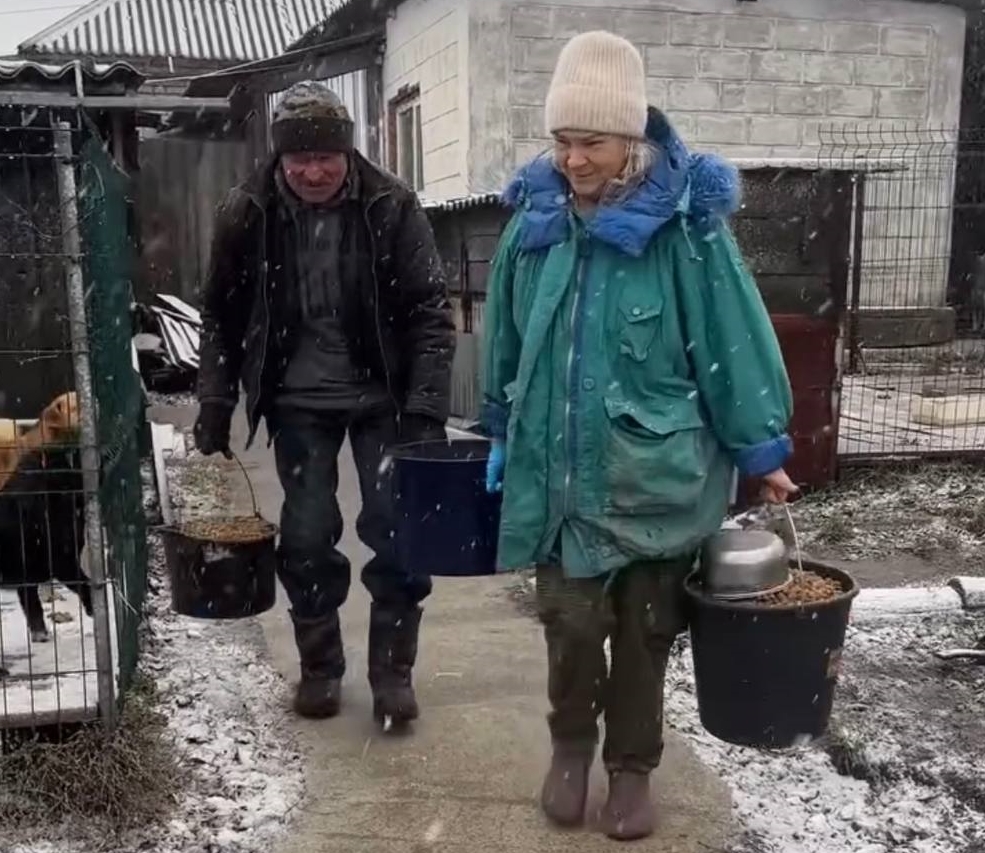 Vladimir and Svetlana Svetlana and a fellow volunteer carry buckets of food through the snow while caring for the rescued animals at Gift a New Life Animal Shelter in Vinnytsia, Ukraine.